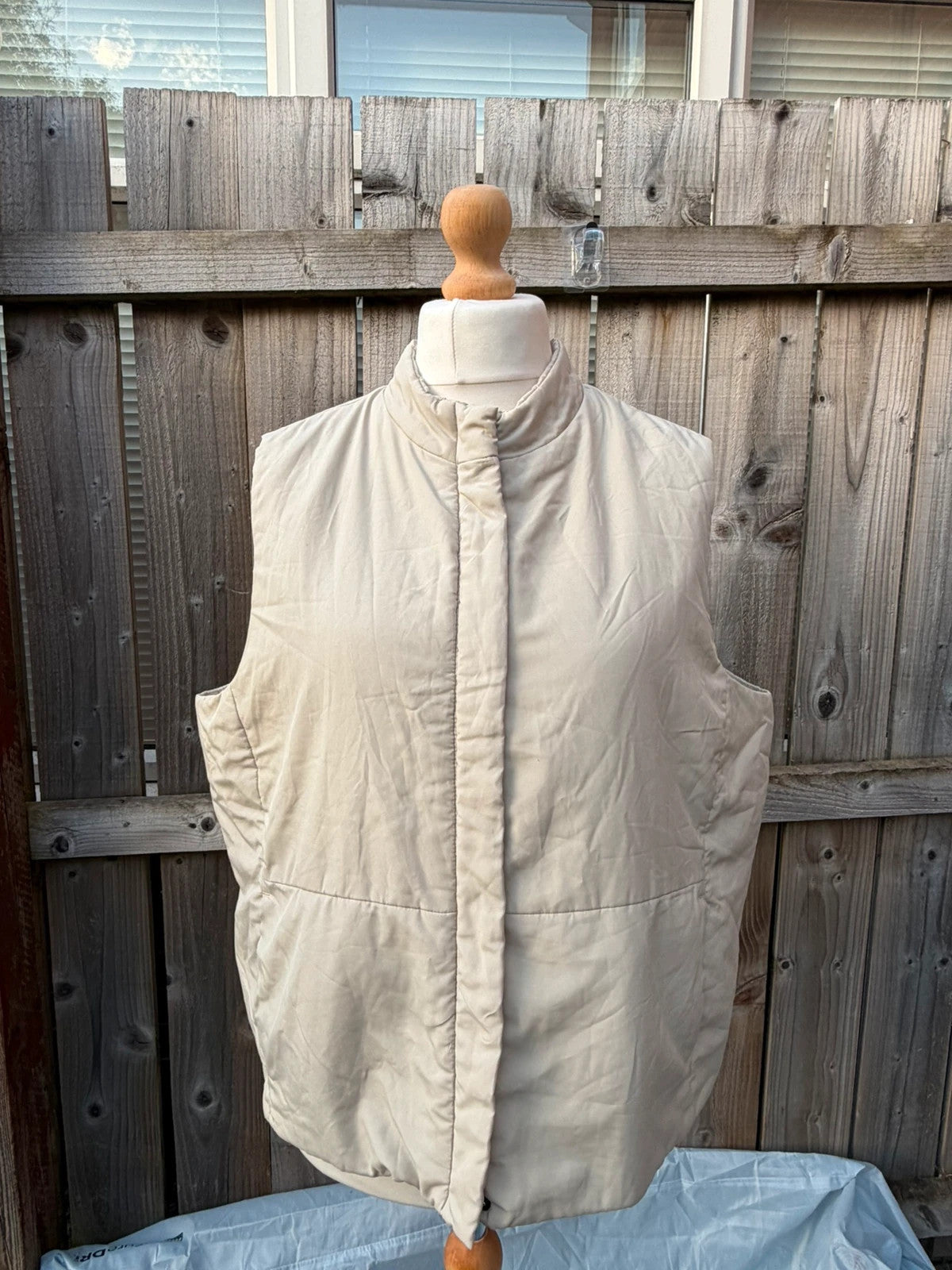 BHS beige padded puffer gilet sleeveless jacket with minimalist design and neutral tones.