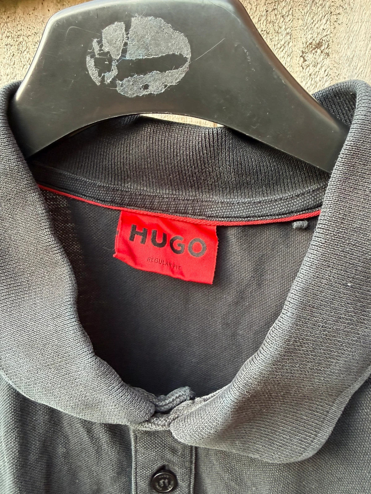 Hugo Boss black polo shirt with red logo, classic fit, premium cotton material.