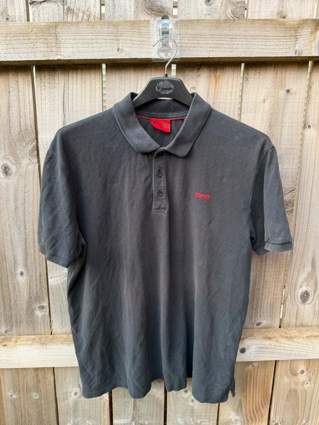 Hugo Boss black polo shirt with red logo, classic fit, premium cotton material.