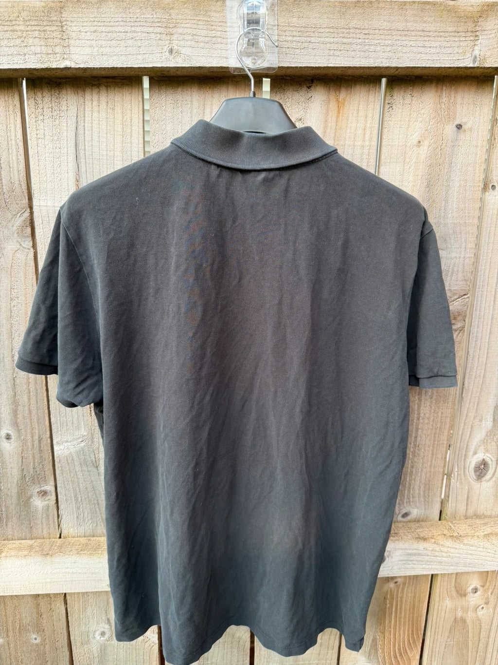 Hugo Boss black polo shirt with red logo, classic fit, premium cotton material.