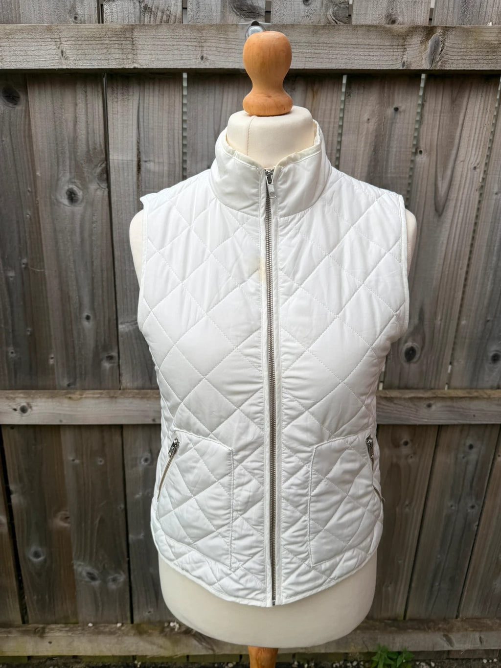 LOFT white sleeveless puffer vest with zip closure and lightweight material.