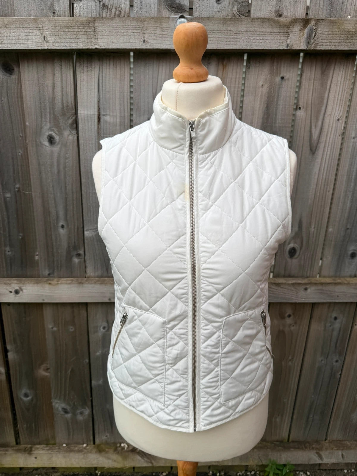 LOFT white sleeveless puffer vest with zip closure and lightweight material.