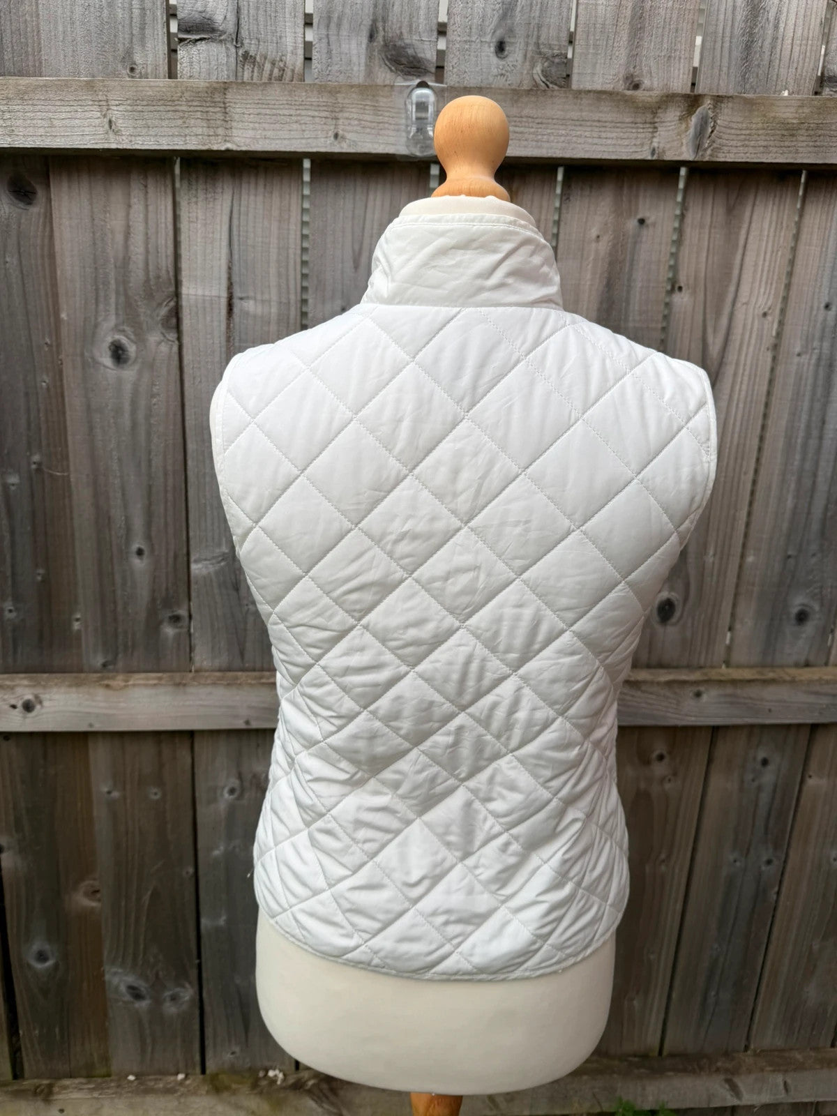 LOFT white sleeveless puffer vest with zip closure and lightweight material.