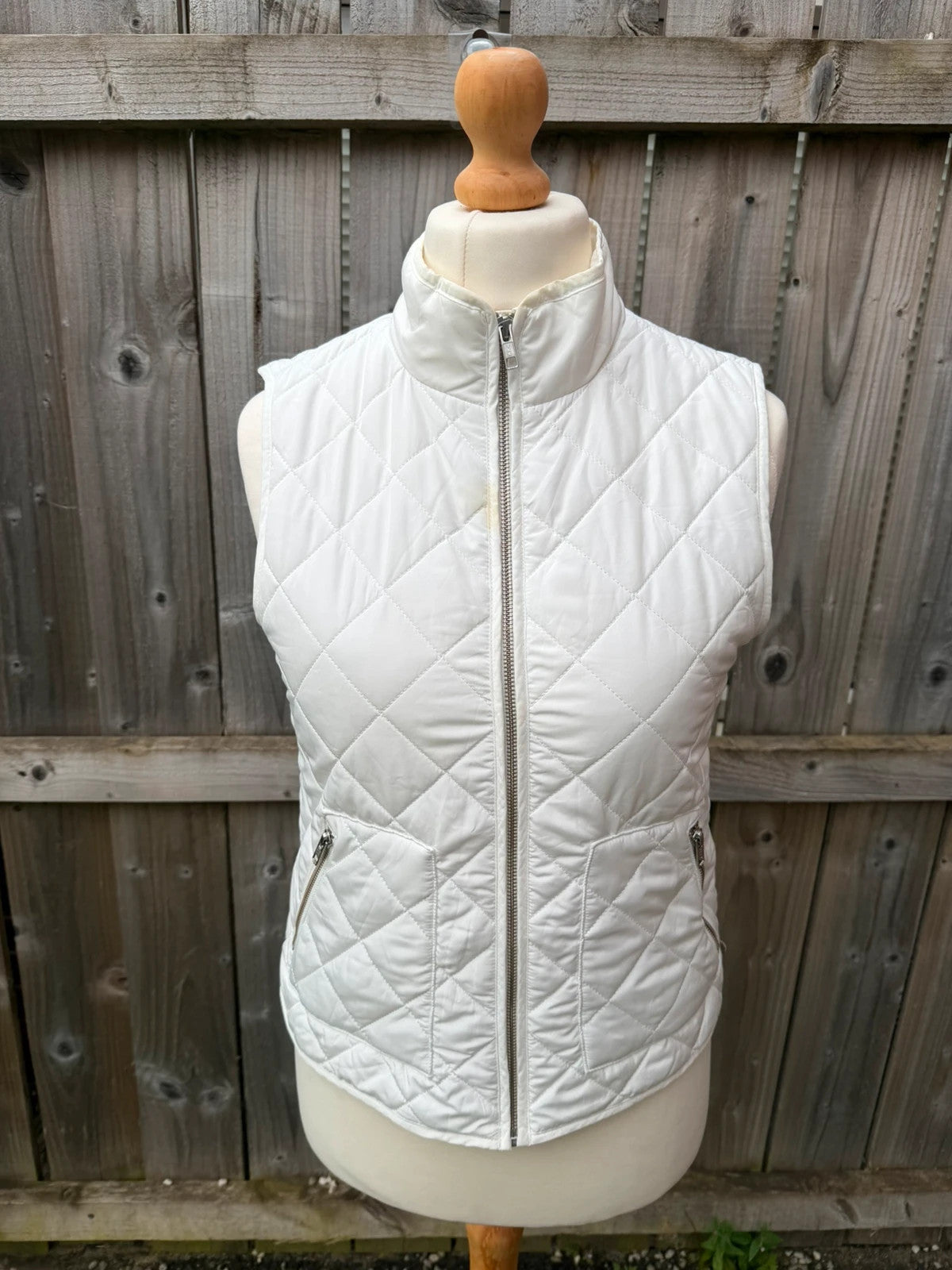 LOFT white sleeveless puffer vest with zip closure and lightweight material.