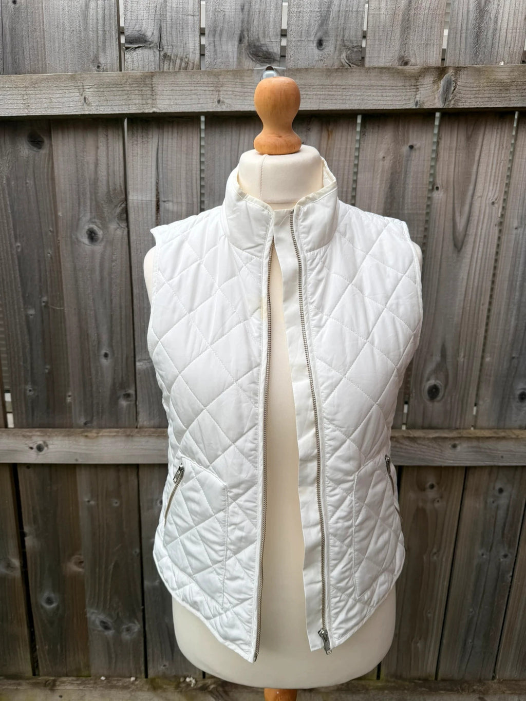 LOFT white sleeveless puffer vest with zip closure and lightweight material.