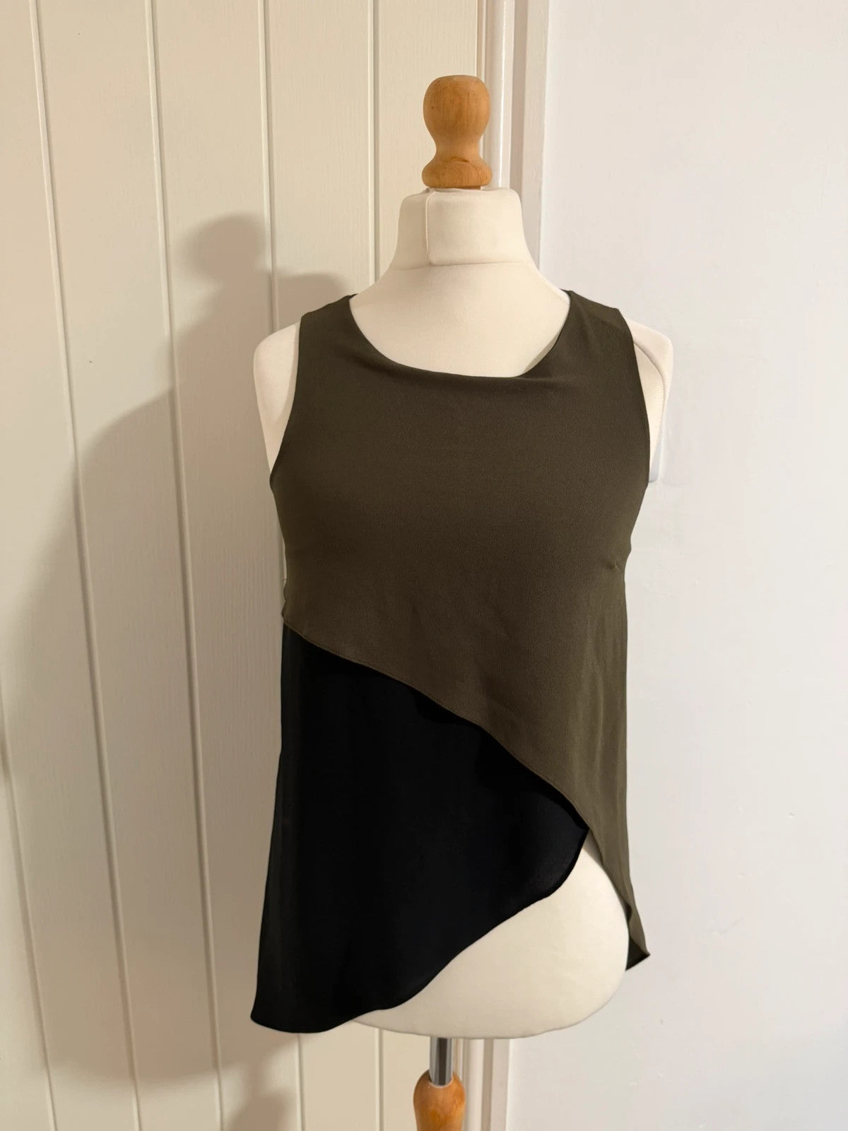 River Island khaki asymmetric sleeveless top with elegant design and smart silhouette.