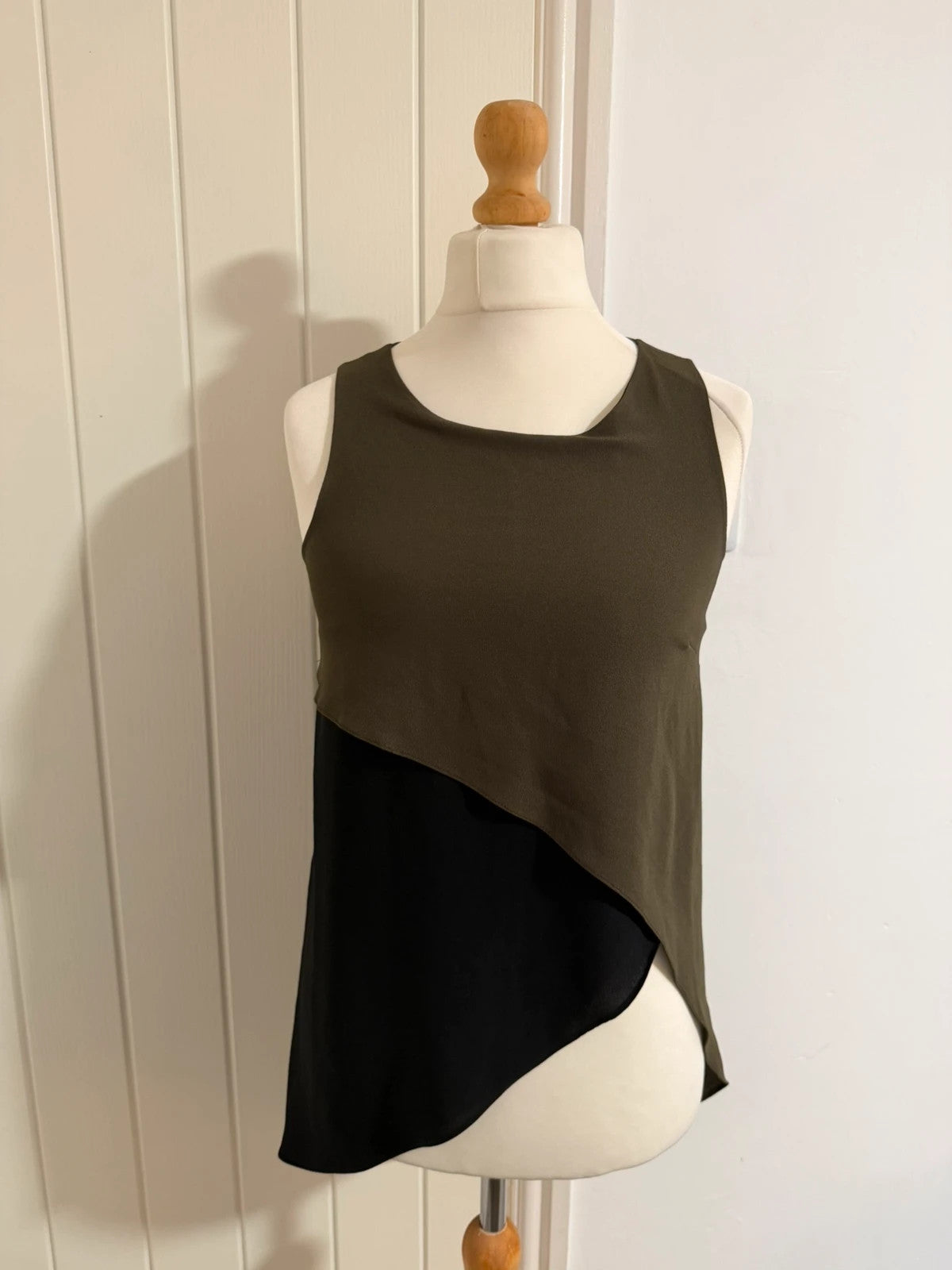 River Island khaki asymmetric sleeveless top with elegant design and smart silhouette.