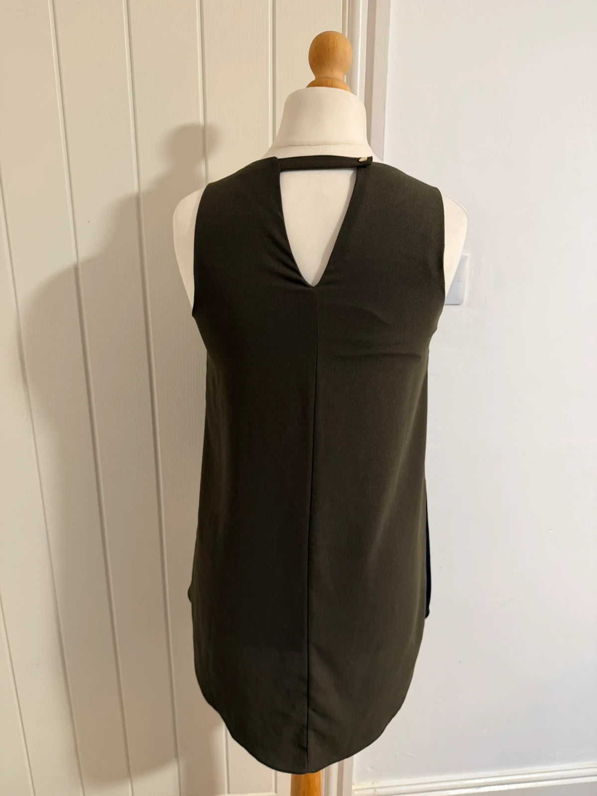 River Island khaki asymmetric sleeveless top with elegant design and smart silhouette.