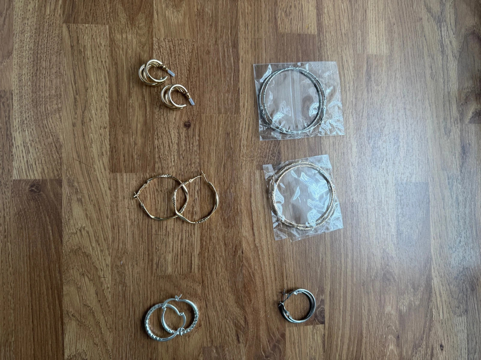Y2K gold and silver large hoop earrings set with shiny metallic finish.