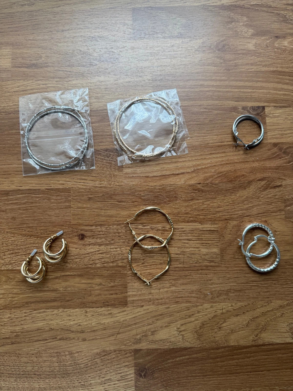 Y2K gold and silver large hoop earrings set with shiny metallic finish.