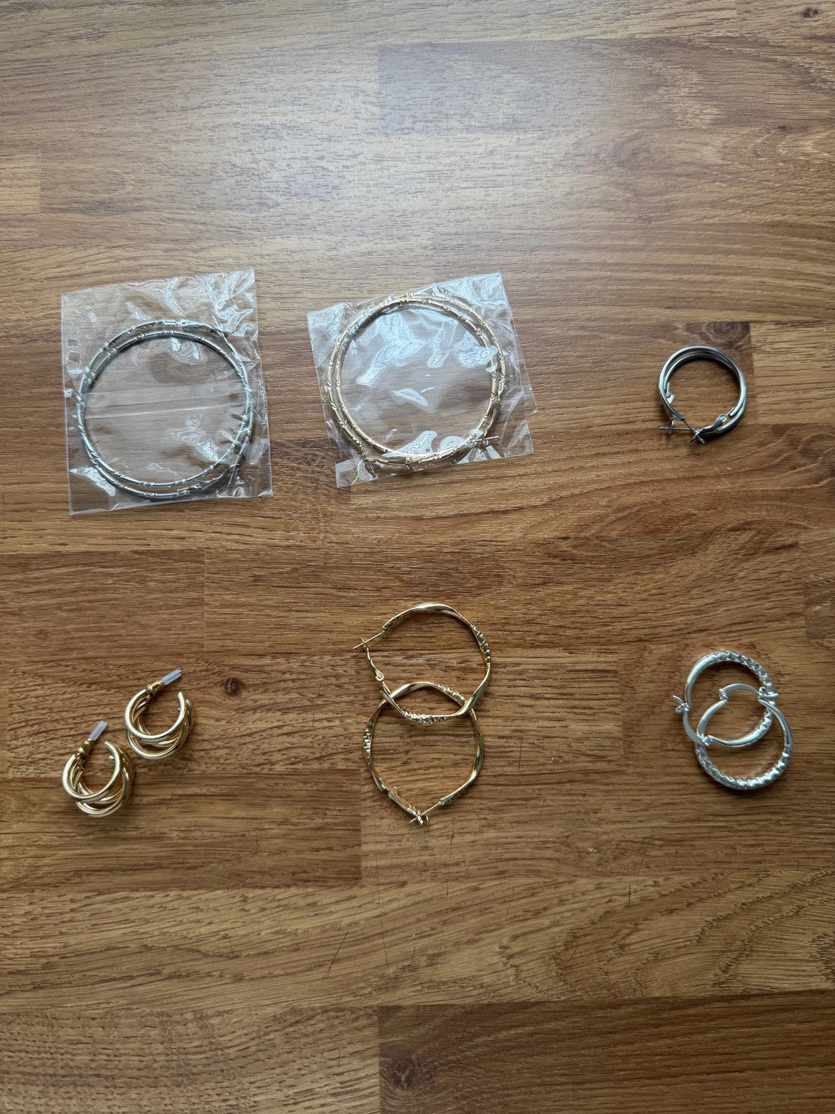 Y2K gold and silver large hoop earrings set with shiny metallic finish.