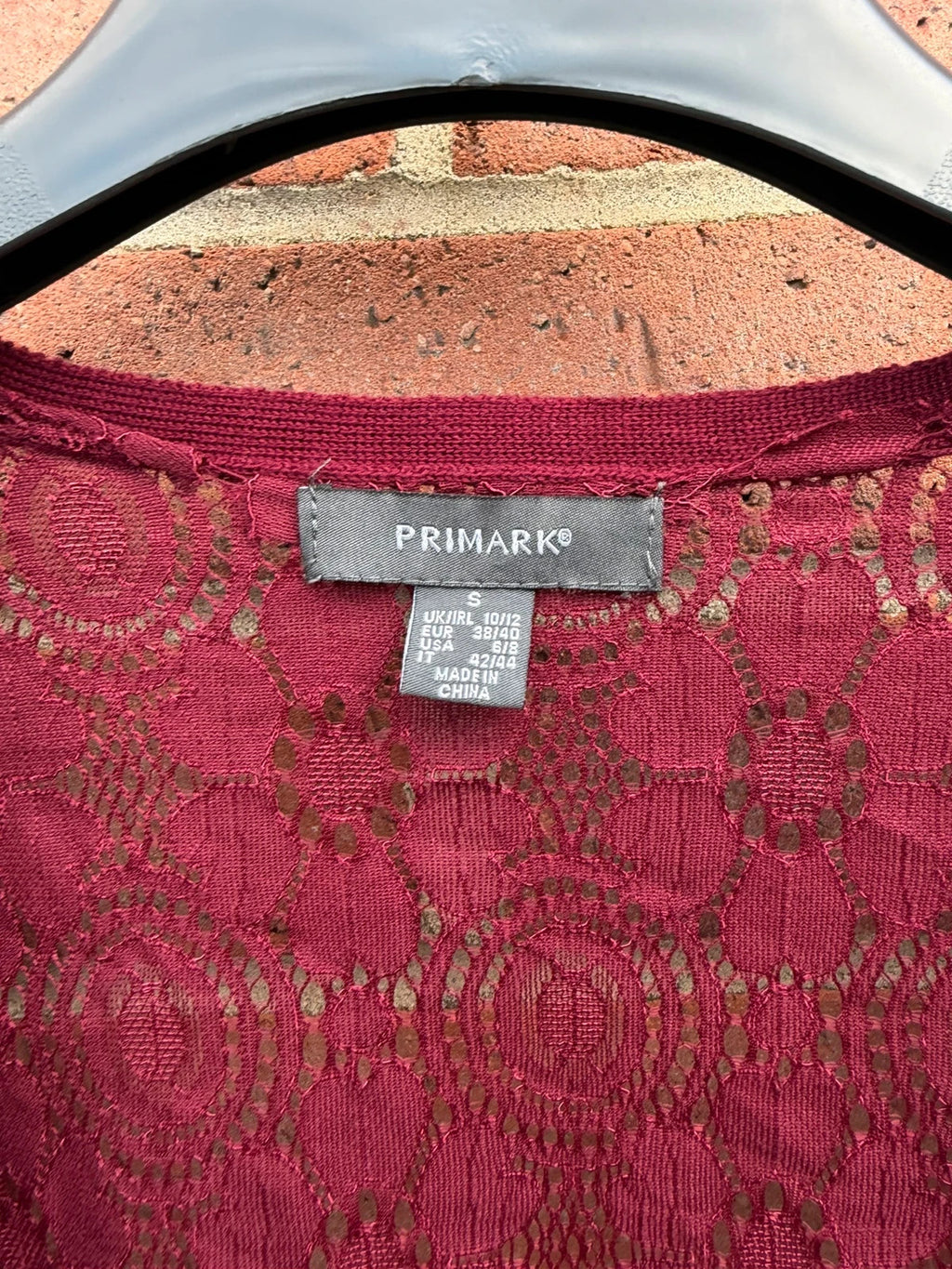 Primark burgundy cardigan with crochet detail and lace back, open front design.