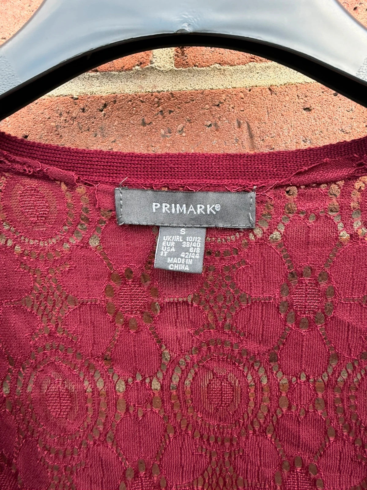 Primark burgundy cardigan with crochet detail and lace back, open front design.