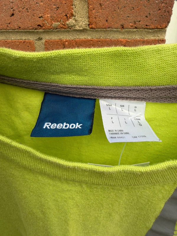 Reebok lime green oversized graphic tee with bold streetwear design and soft fabric.
