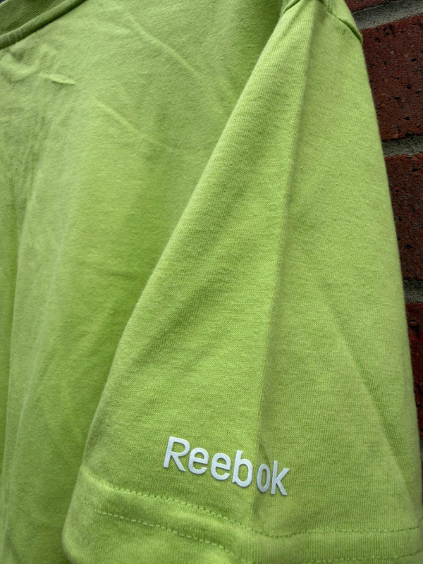 Reebok lime green oversized graphic tee with bold streetwear design and soft fabric.