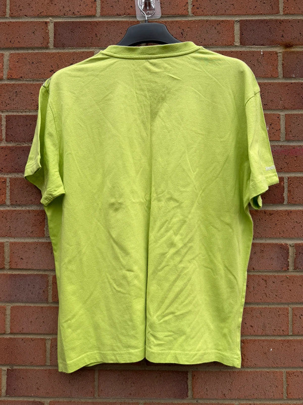 Reebok lime green oversized graphic tee with bold streetwear design and soft fabric.