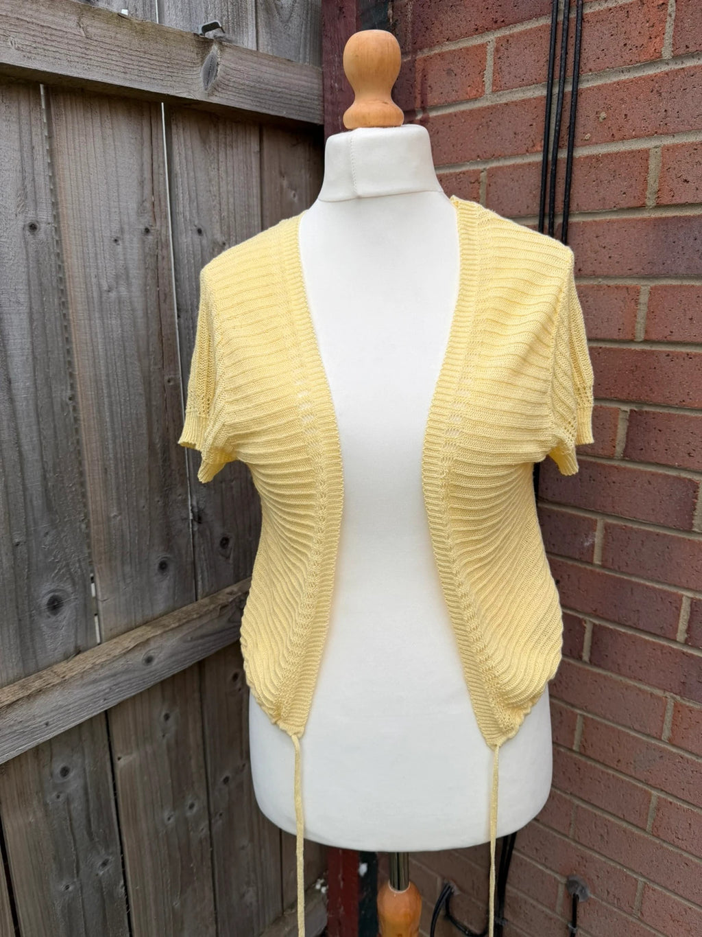 Simply Be yellow knit cropped bolero shrug with tie front detail.