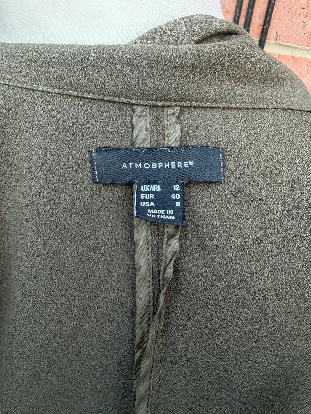 Atmosphere khaki sleeveless blazer with utility pockets and Y2K style details.