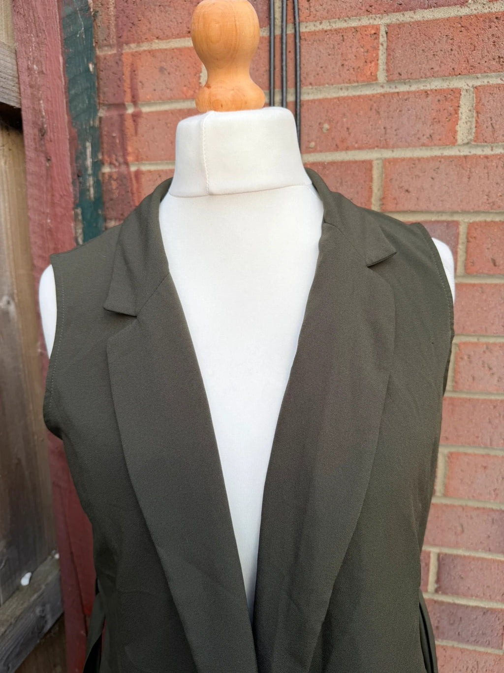 Atmosphere khaki sleeveless blazer with utility pockets and Y2K style details.