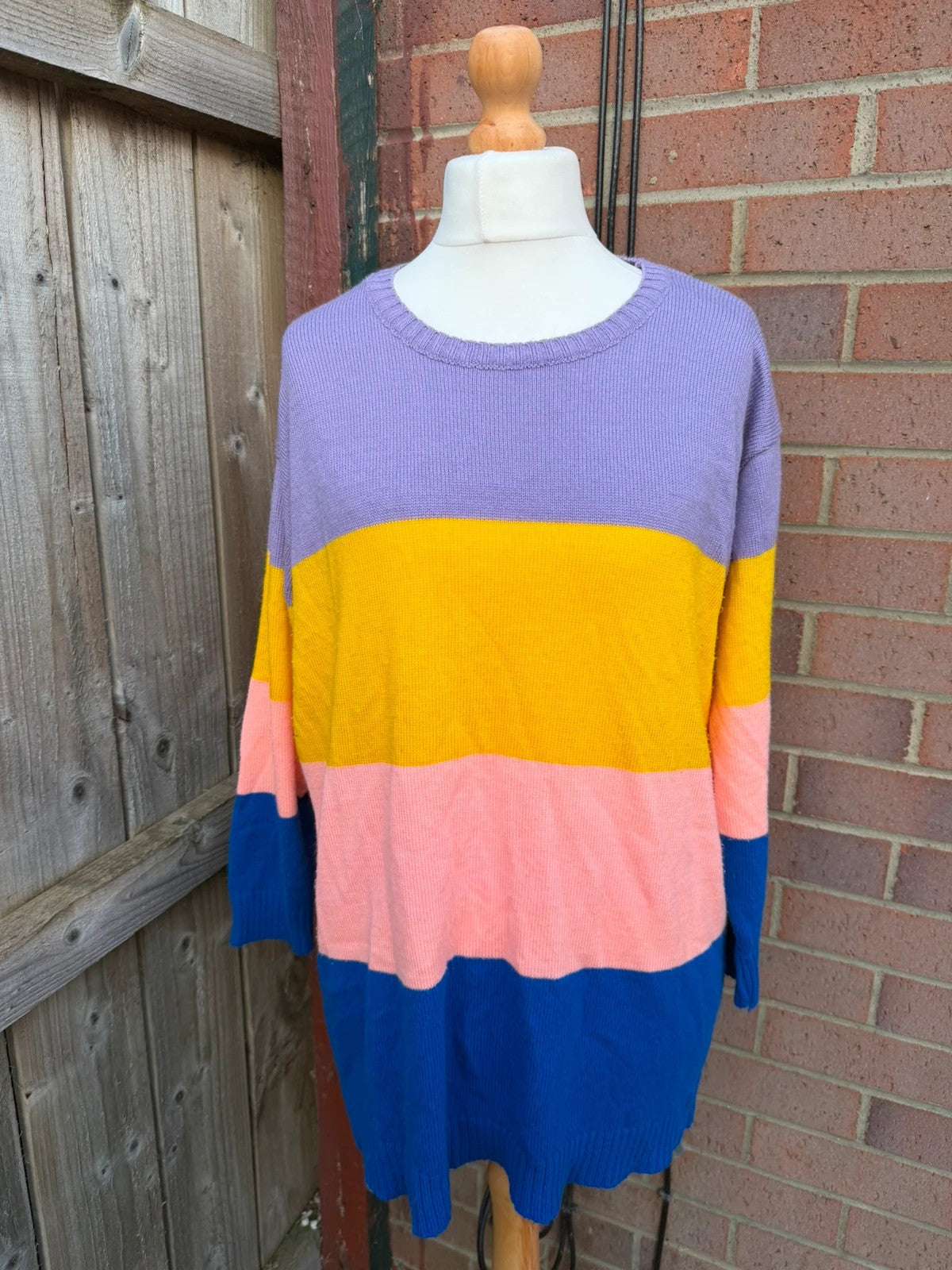 Colour block oversized jumper in pink, yellow, and blue knit with no label.