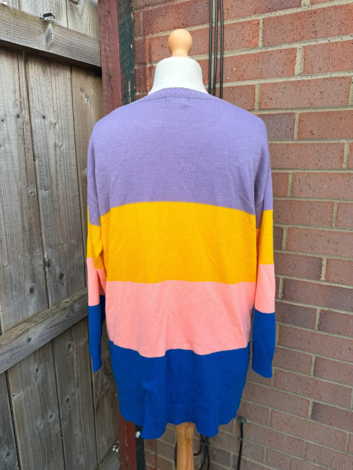 Colour block oversized jumper in pink, yellow, and blue knit with no label.