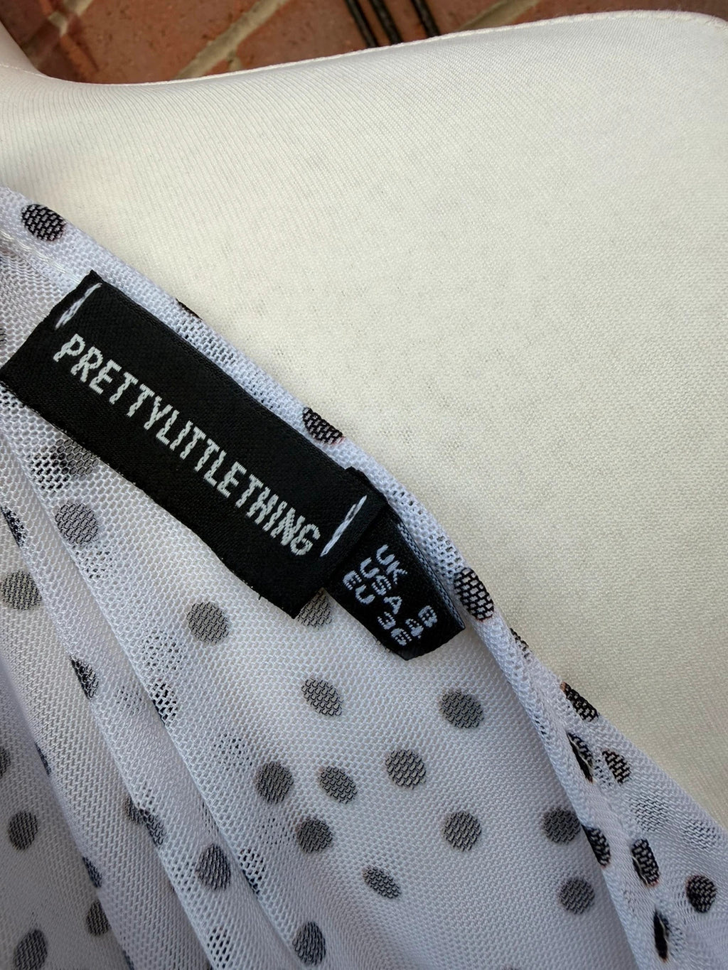 PrettyLittleThing black and white polka dot mesh crop top with coquette fairy style.