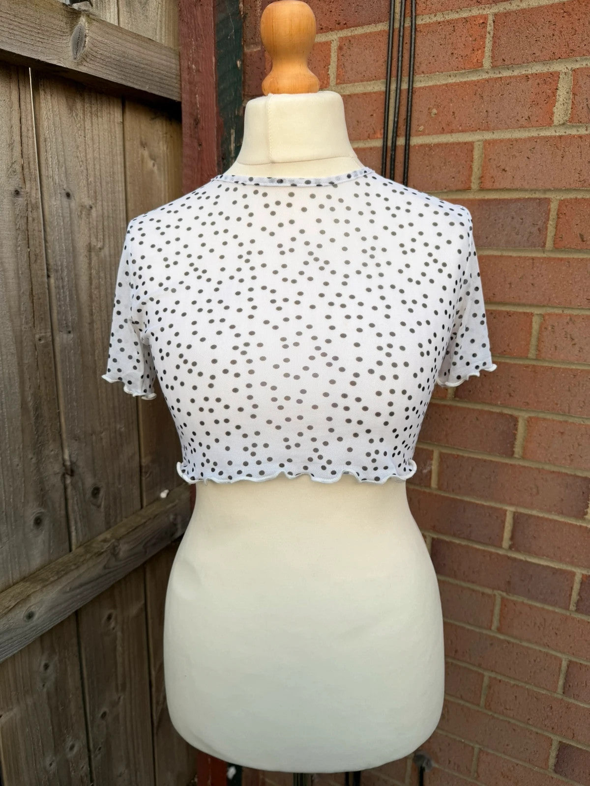 PrettyLittleThing black and white polka dot mesh crop top with coquette fairy style.