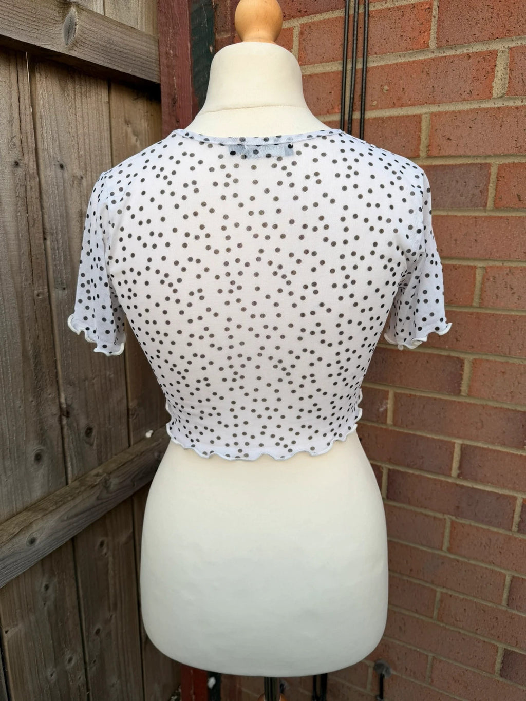 PrettyLittleThing black and white polka dot mesh crop top with coquette fairy style.