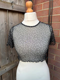 PrettyLittleThing black sheer mesh crop top with polka dot pattern and festival style.