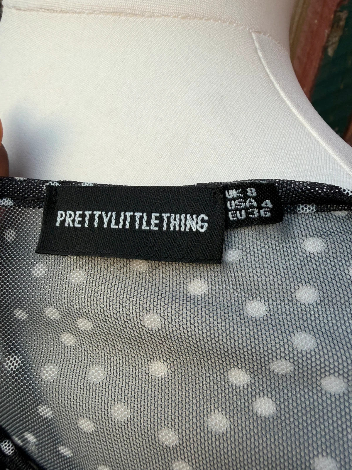 PrettyLittleThing black sheer mesh crop top with polka dot pattern and festival style.