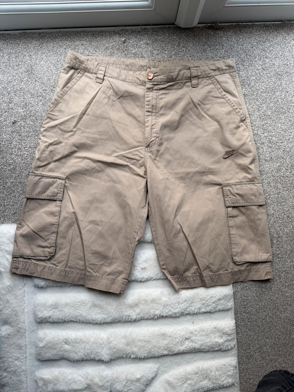 Nike beige cargo shorts with utility pockets and logo detail.