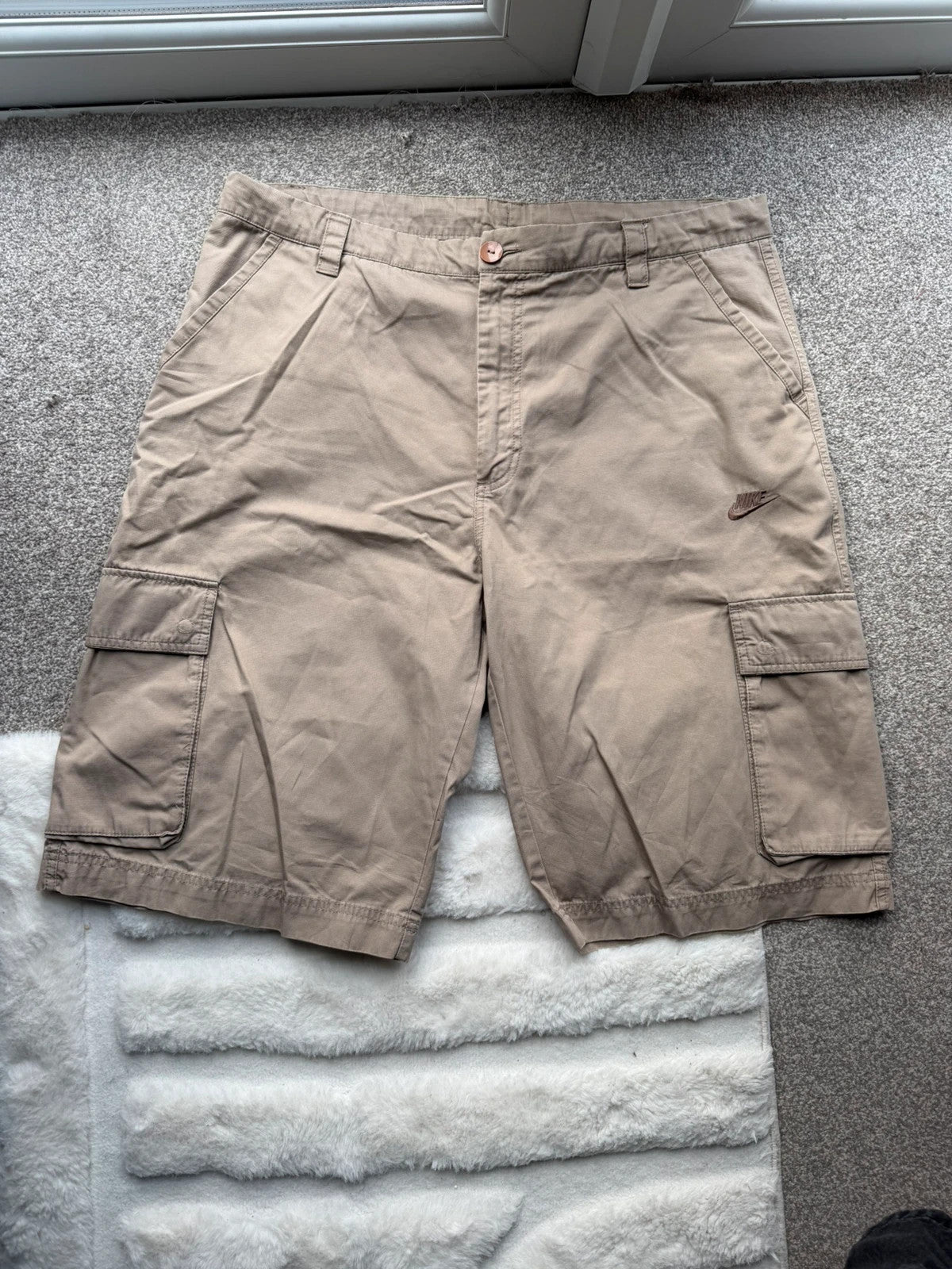 Nike beige cargo shorts with utility pockets and logo detail.