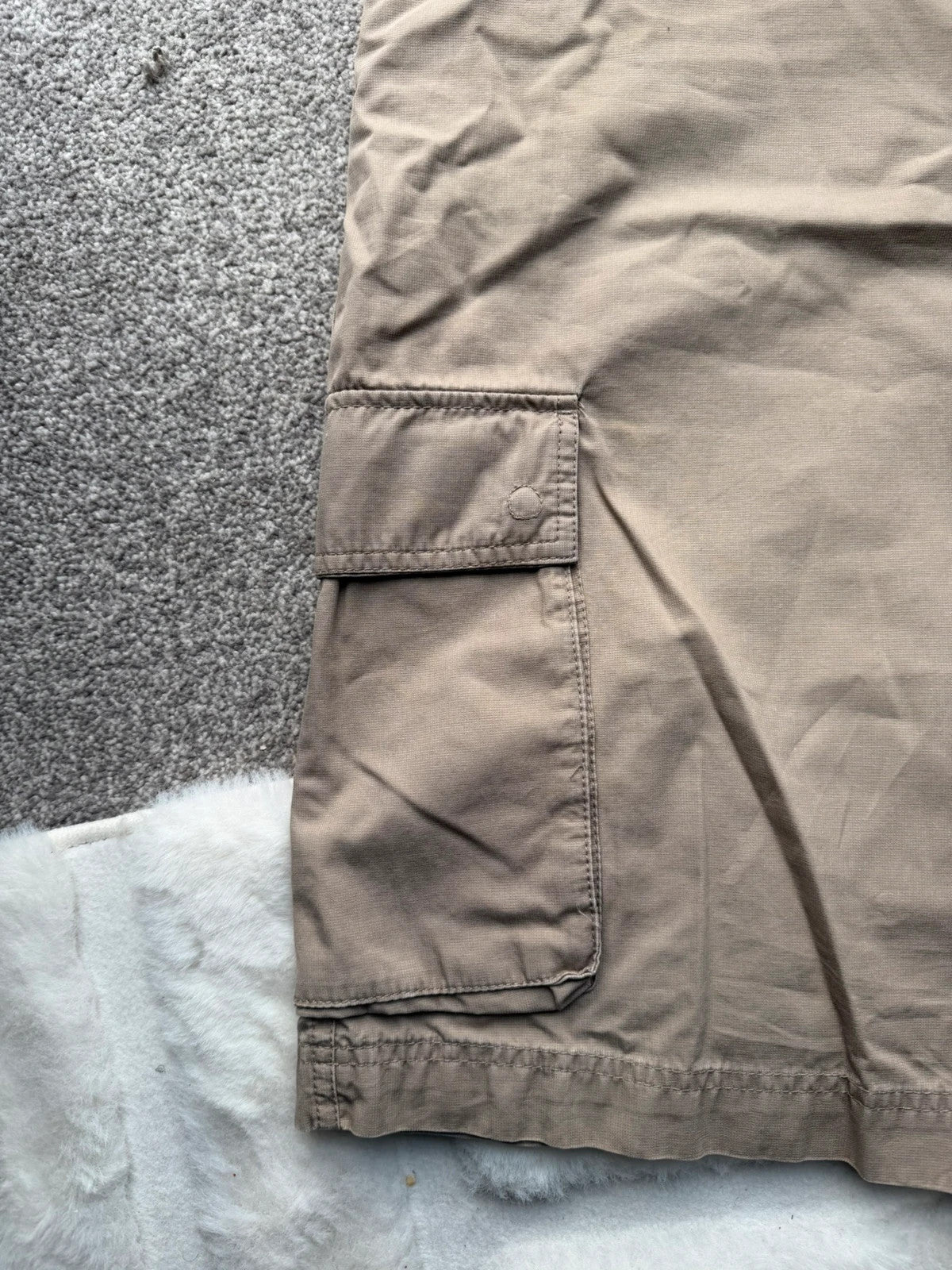 Nike beige cargo shorts with utility pockets and logo detail.