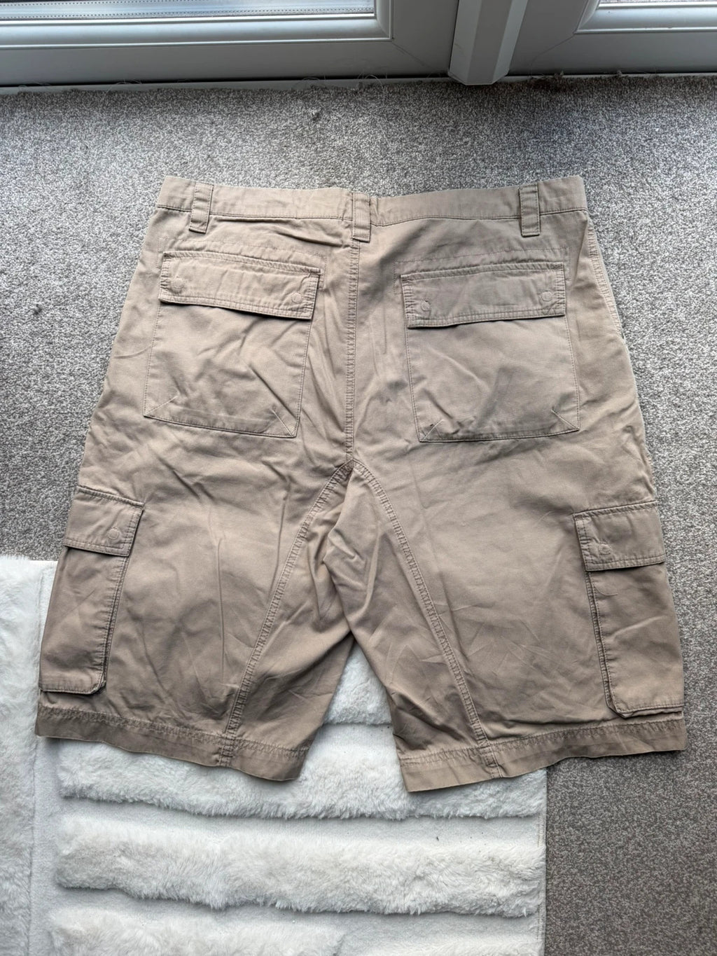 Nike beige cargo shorts with utility pockets and logo detail.