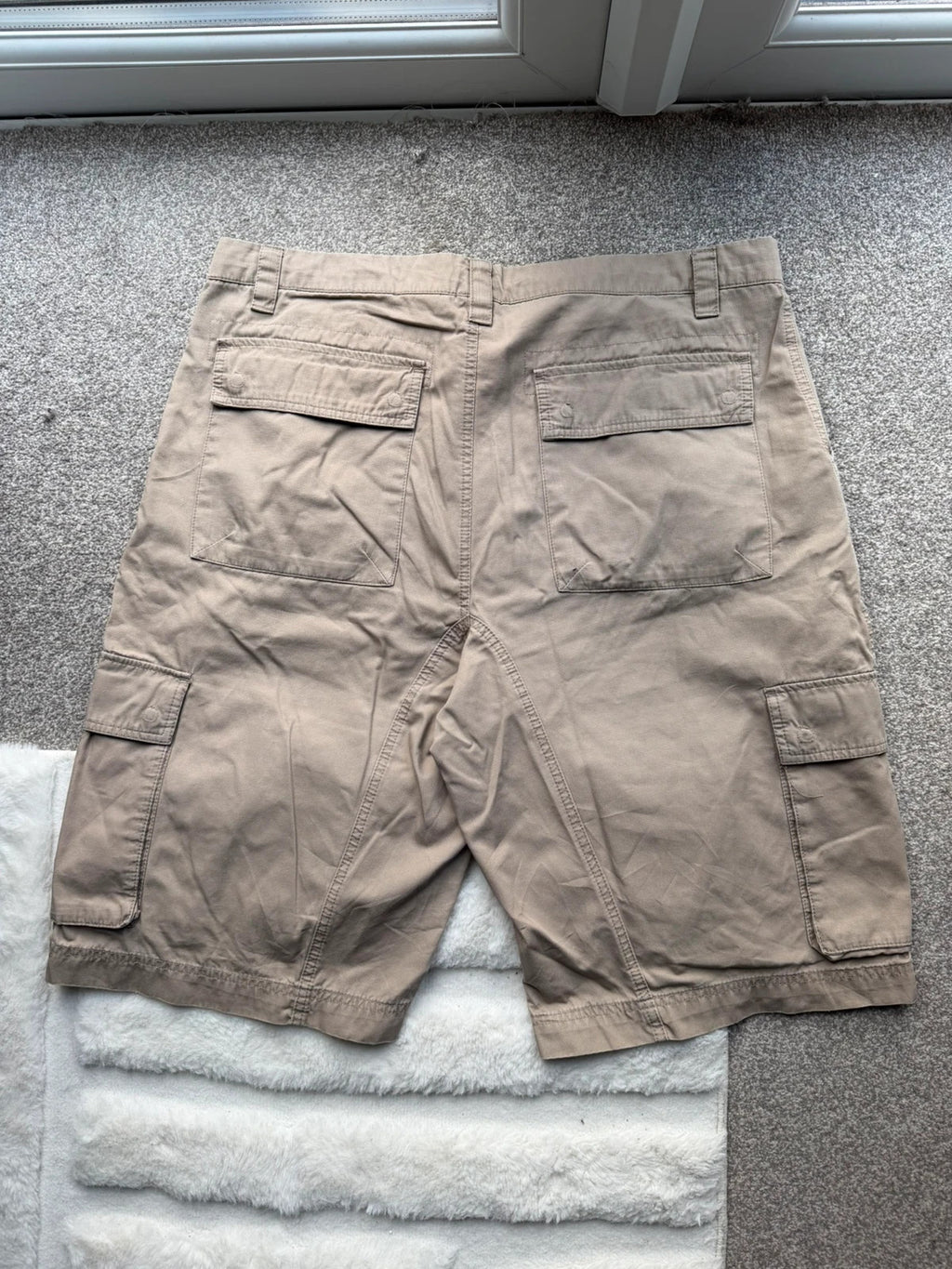 Nike beige cargo shorts with utility pockets and logo detail.