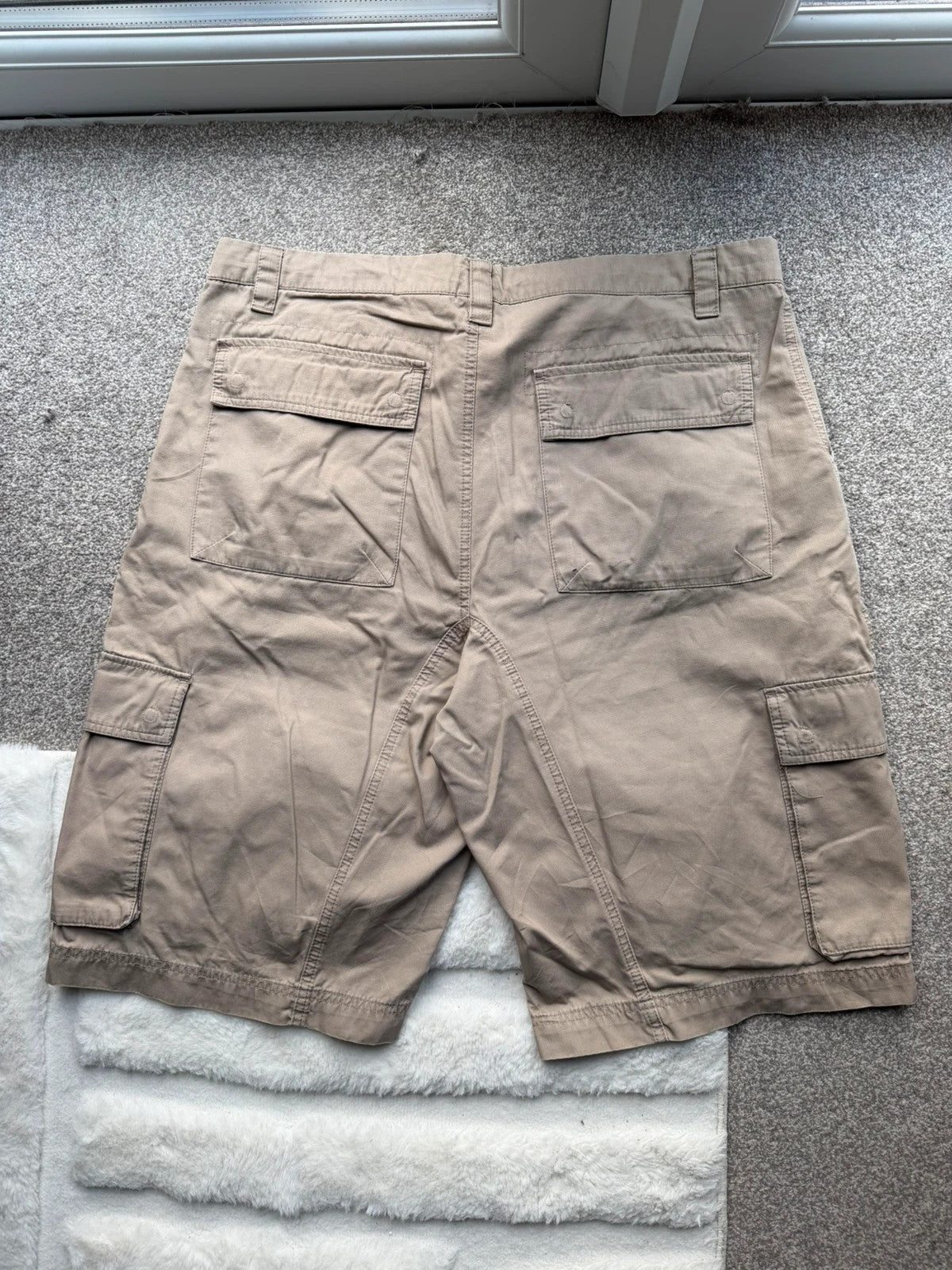 Nike beige cargo shorts with utility pockets and logo detail.