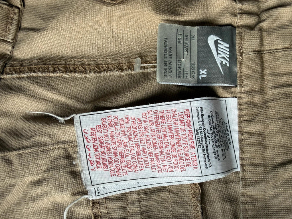 Nike beige cargo shorts with utility pockets and logo detail.
