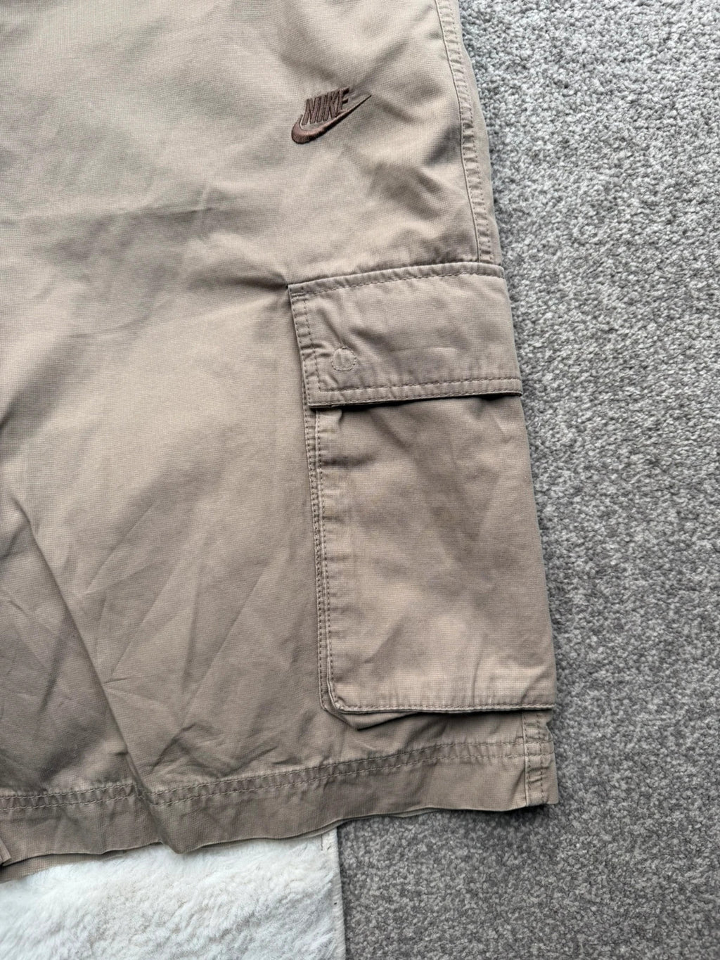 Nike beige cargo shorts with utility pockets and logo detail.