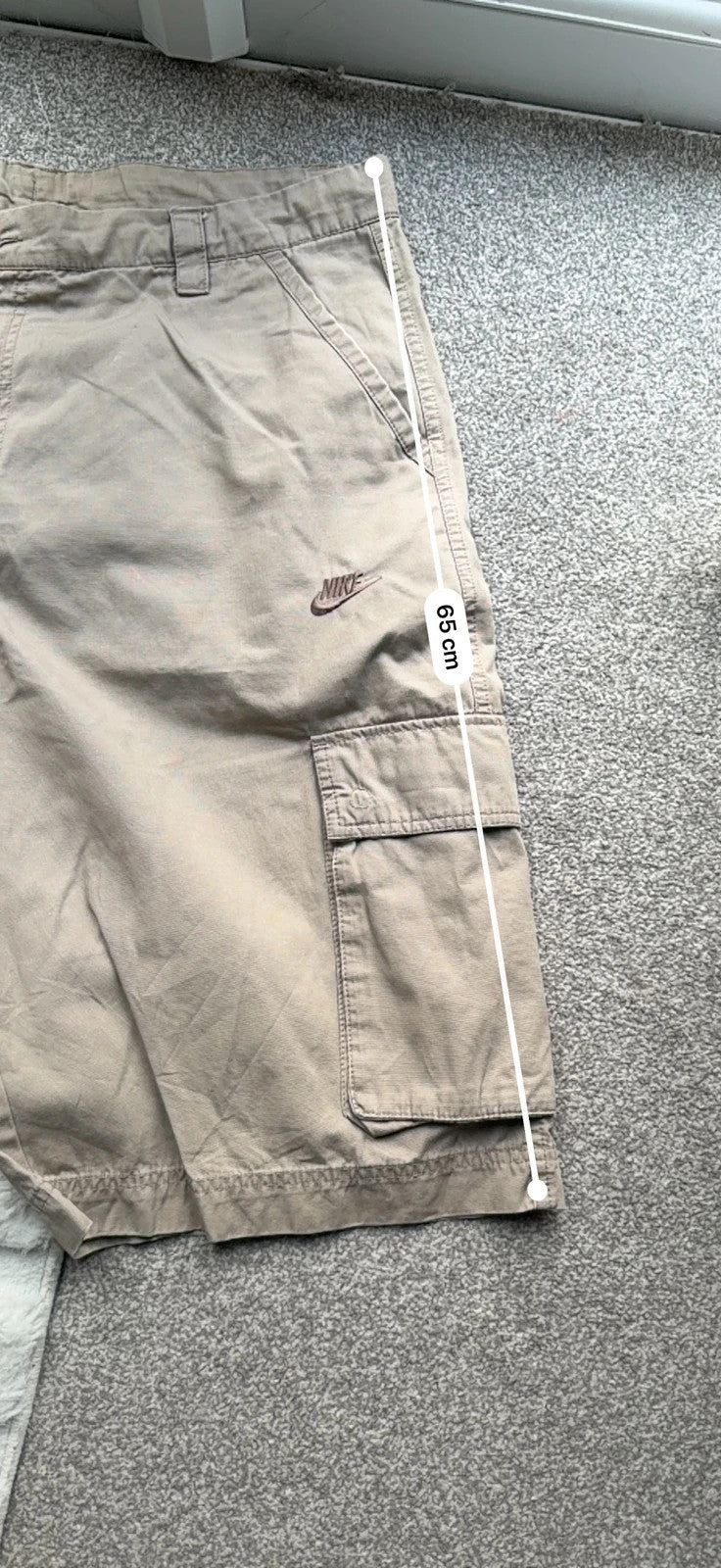 Nike beige cargo shorts with utility pockets and logo detail.