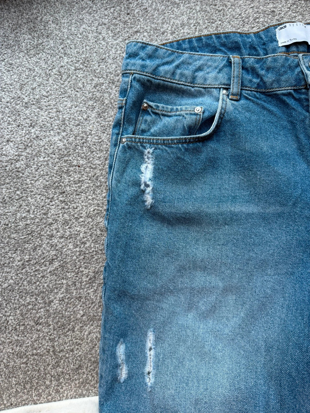 ASOS blue distressed denim shorts with frayed hem and casual Y2K style.