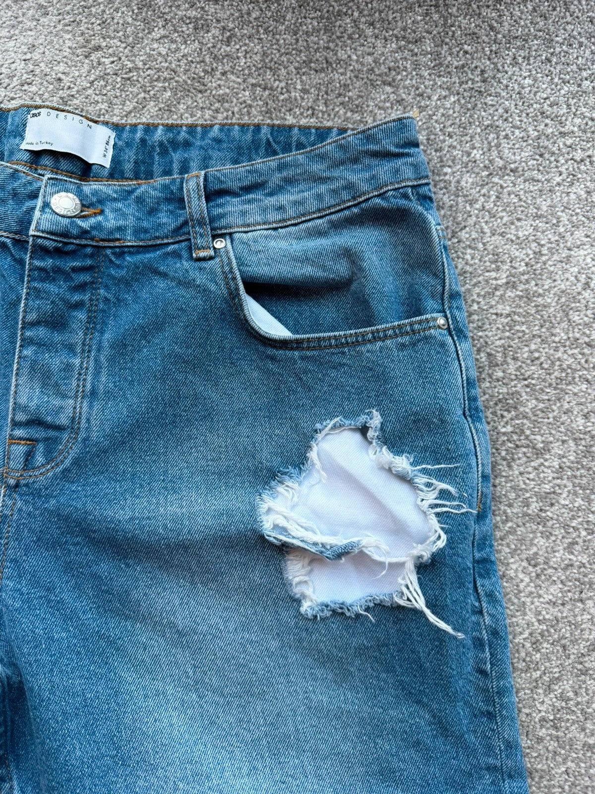 ASOS blue distressed denim shorts with frayed hem and casual Y2K style.