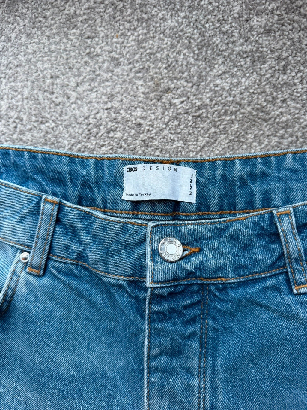 ASOS blue distressed denim shorts with frayed hem and casual Y2K style.