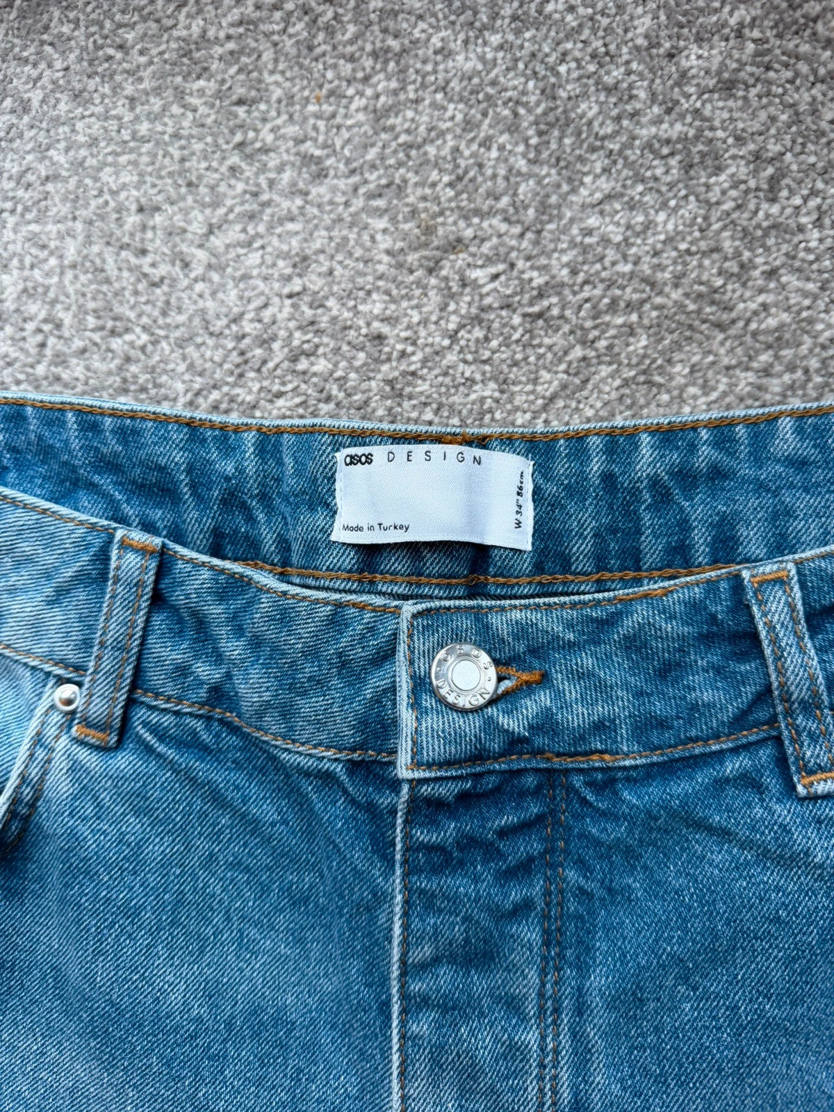 ASOS blue distressed denim shorts with frayed hem and casual Y2K style.