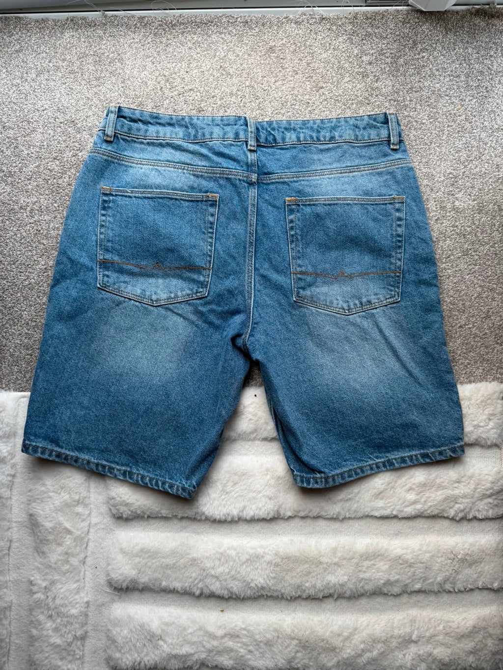 ASOS blue distressed denim shorts with frayed hem and casual Y2K style.
