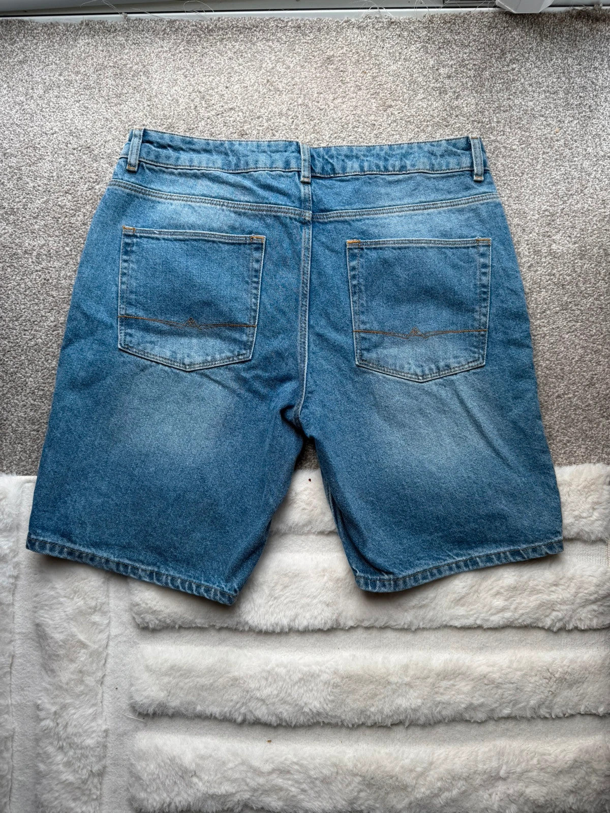 ASOS blue distressed denim shorts with frayed hem and casual Y2K style.