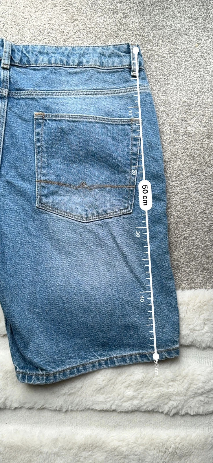 ASOS blue distressed denim shorts with frayed hem and casual Y2K style.