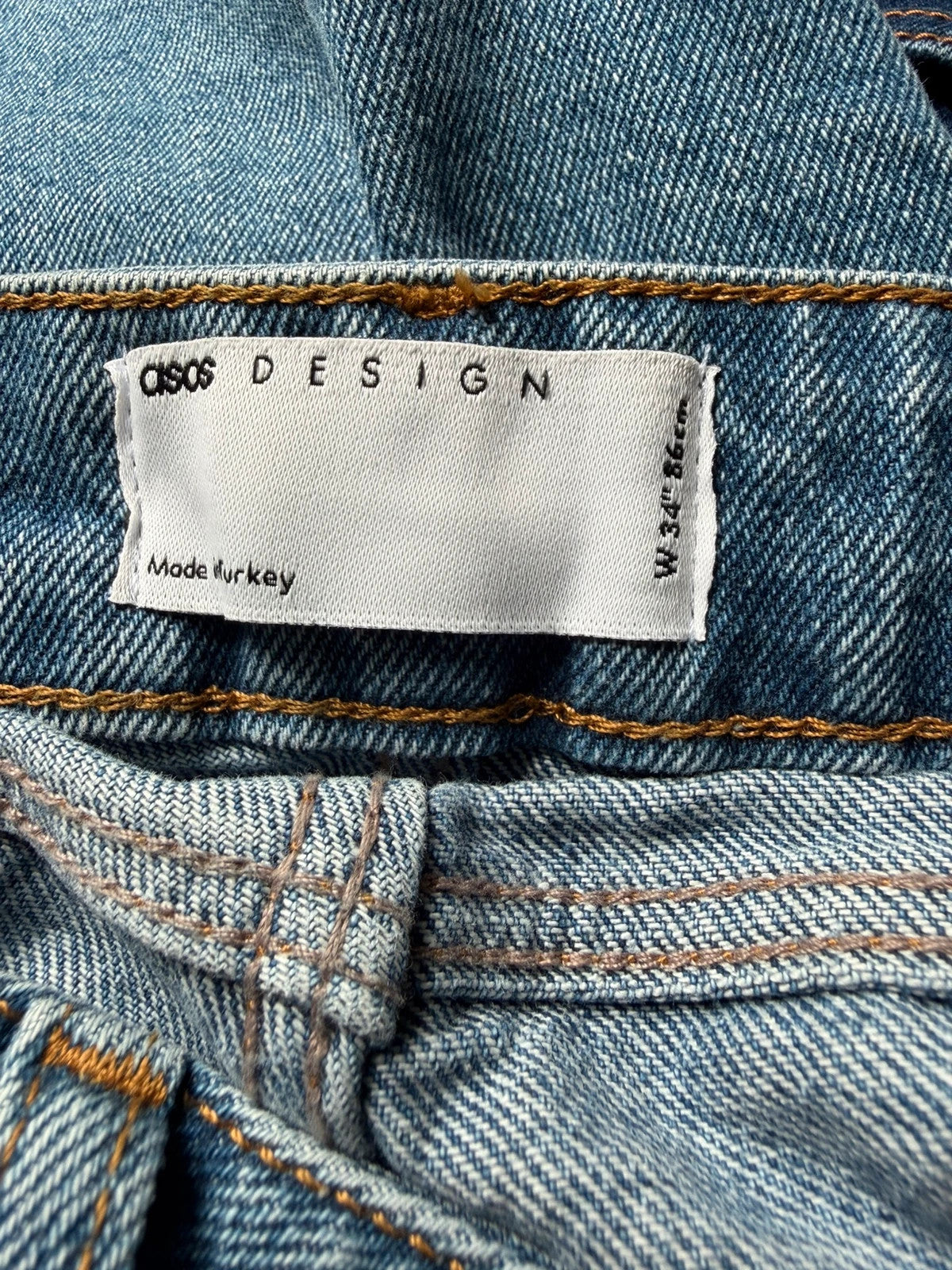 ASOS blue distressed denim shorts with frayed hem and casual Y2K style.