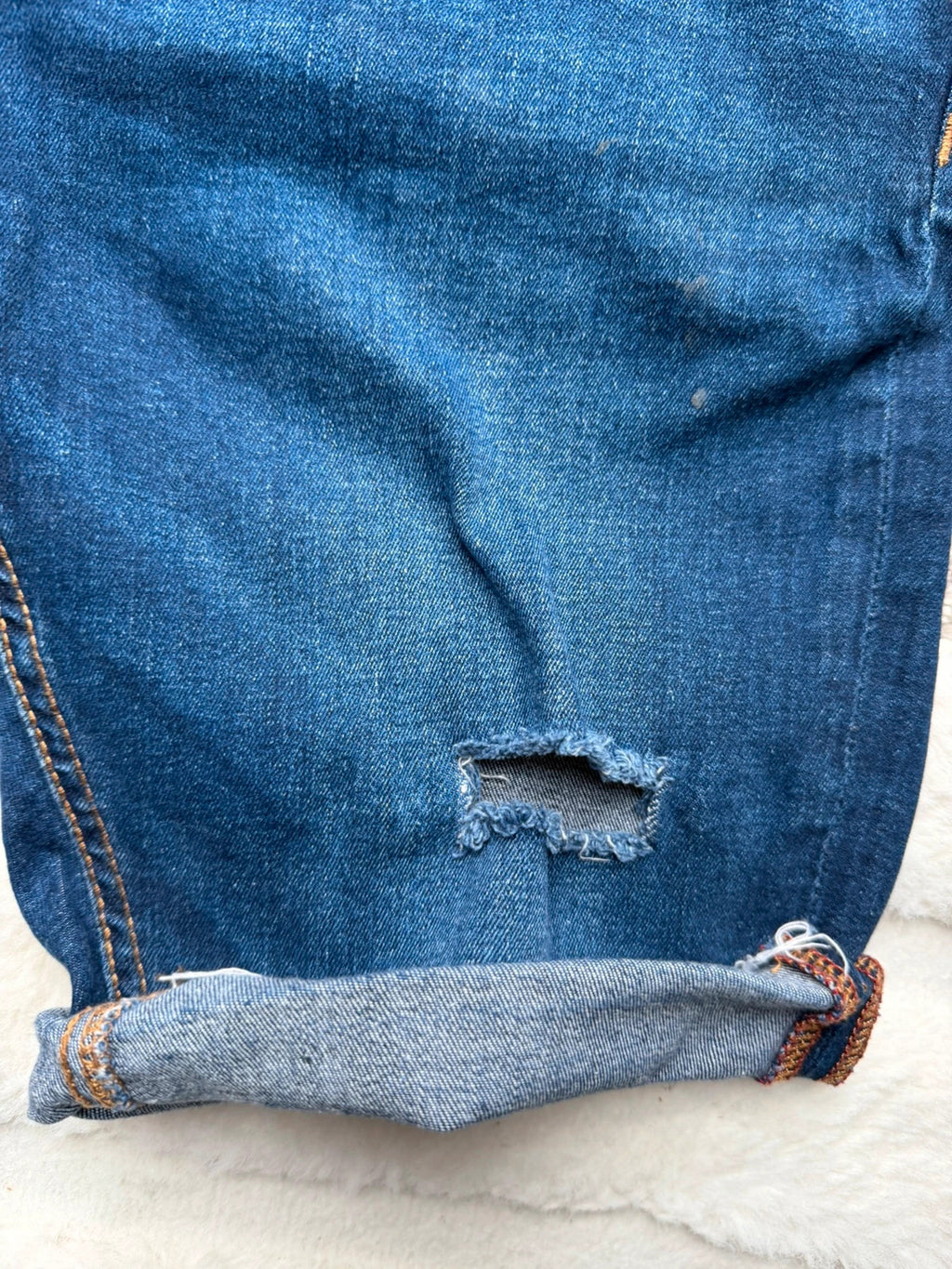 Ringspun blue denim shorts with distressed details and rolled hem.