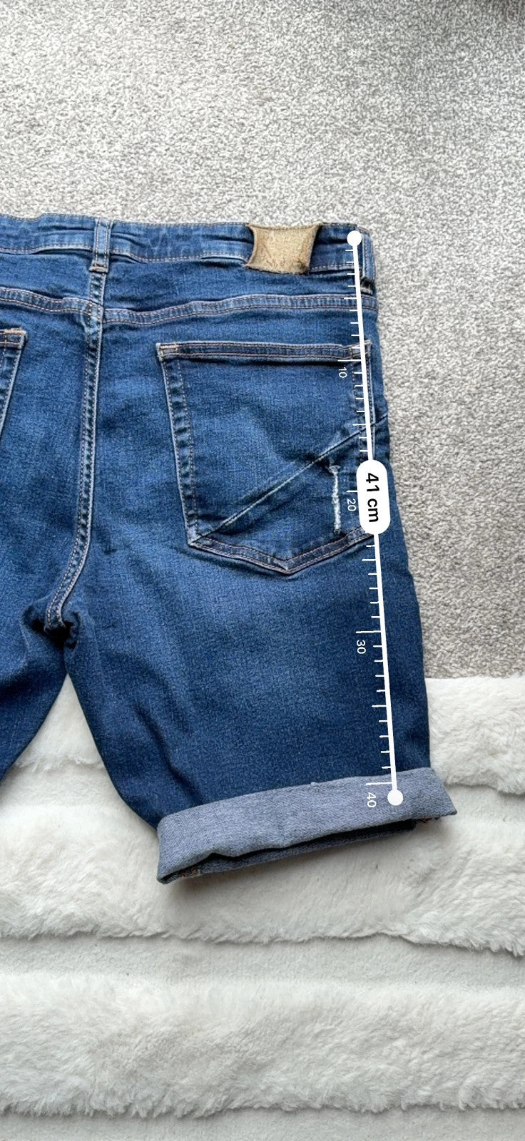 Ringspun blue denim shorts with distressed details and rolled hem.