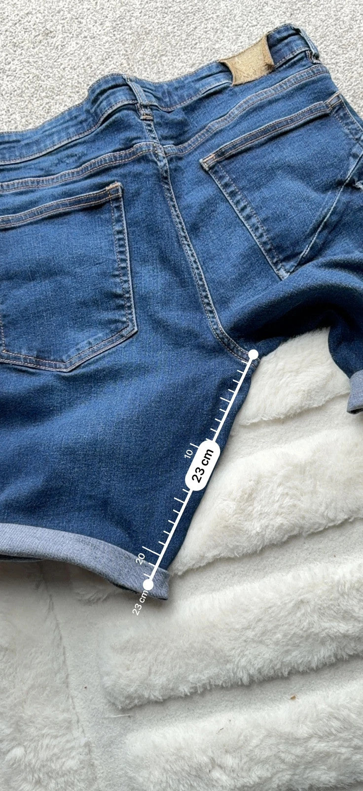 Ringspun blue denim shorts with distressed details and rolled hem.